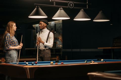 Two people shooting pool